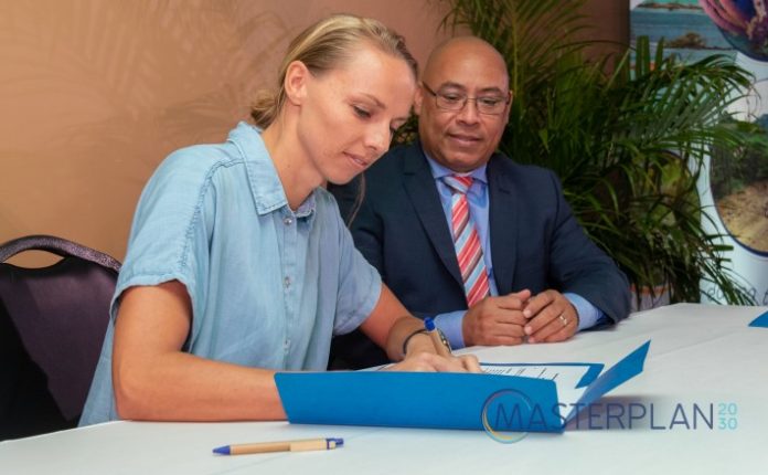 Diputado Elvis Tjin Asjoe i Gerjanne Voortman di fundashon ‘Green Destinations’ ta firma e akuerdo di entendimentu.