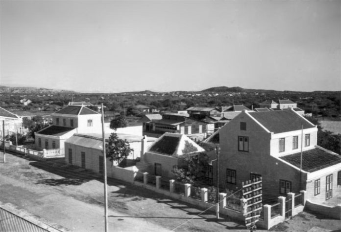 Tienda di Don Juan Coen tabata den e edifisio visibel na man robes riba e foto aki.